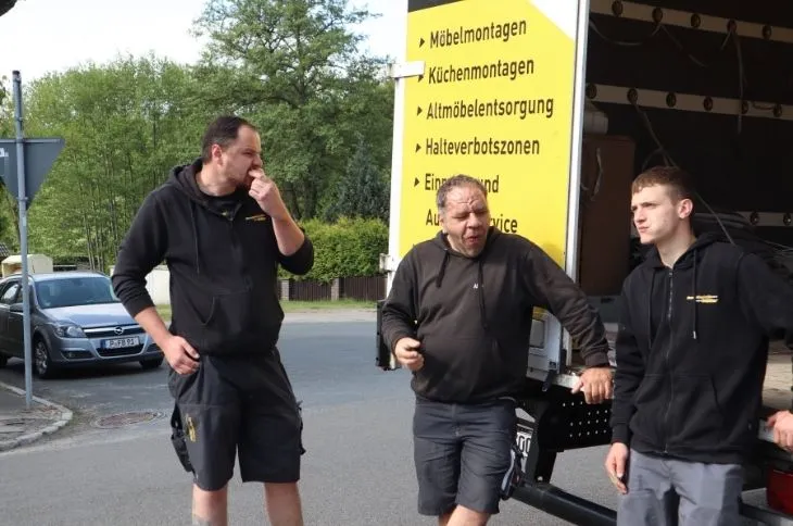 umzugshelfer team bespricht umzug vor umzugswagen